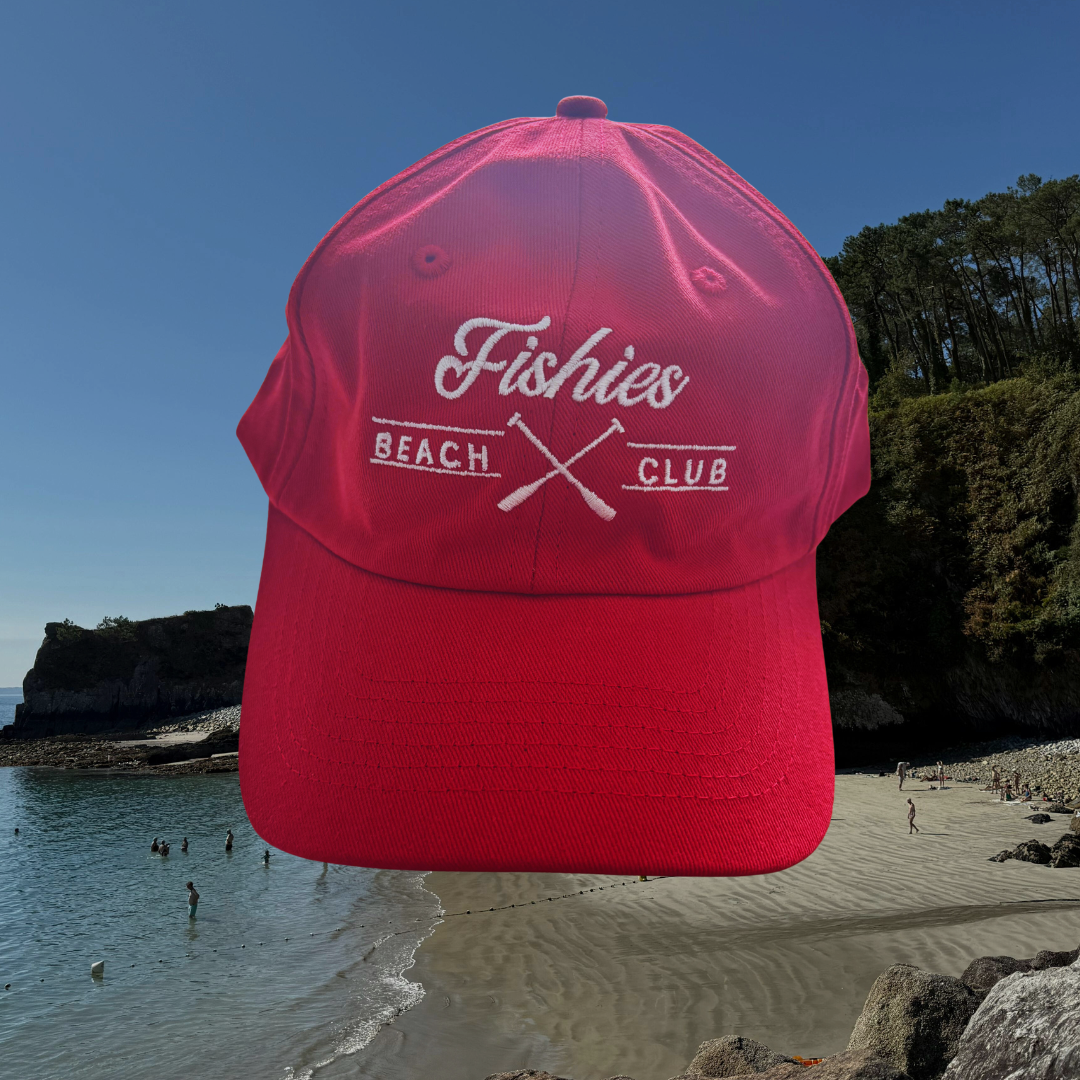 Red cap with 'Fishies Beach Club' logo on a beach background