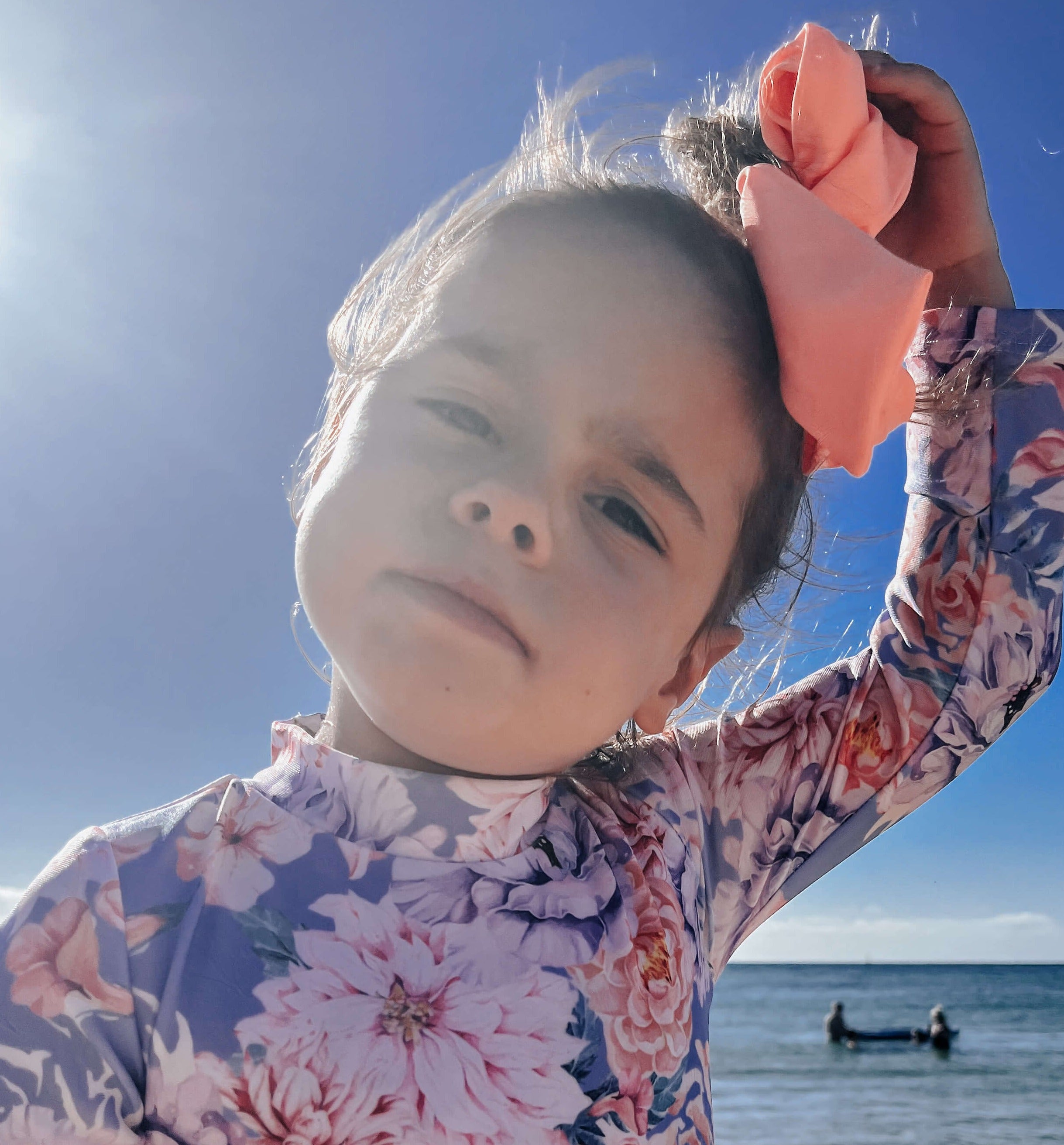 girl in snapsuit swimwear with a bright orange head band hair tie