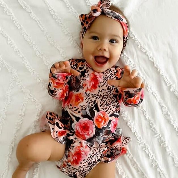 baby girl in a leopard print swimsuit with nappy change snaps