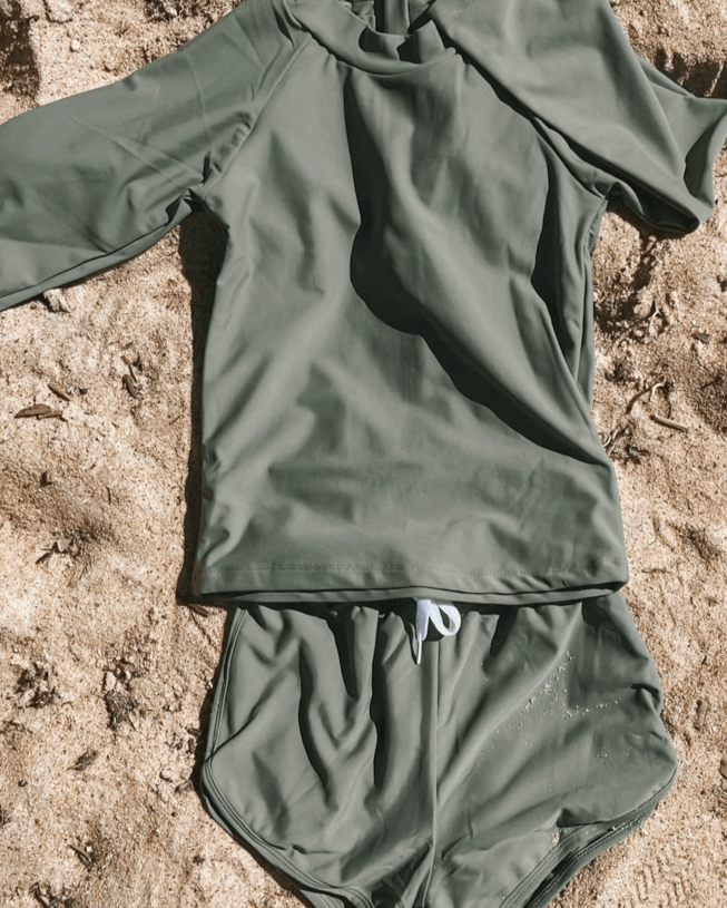 Olive rash set for girls and boys and babies laying flat on the sand