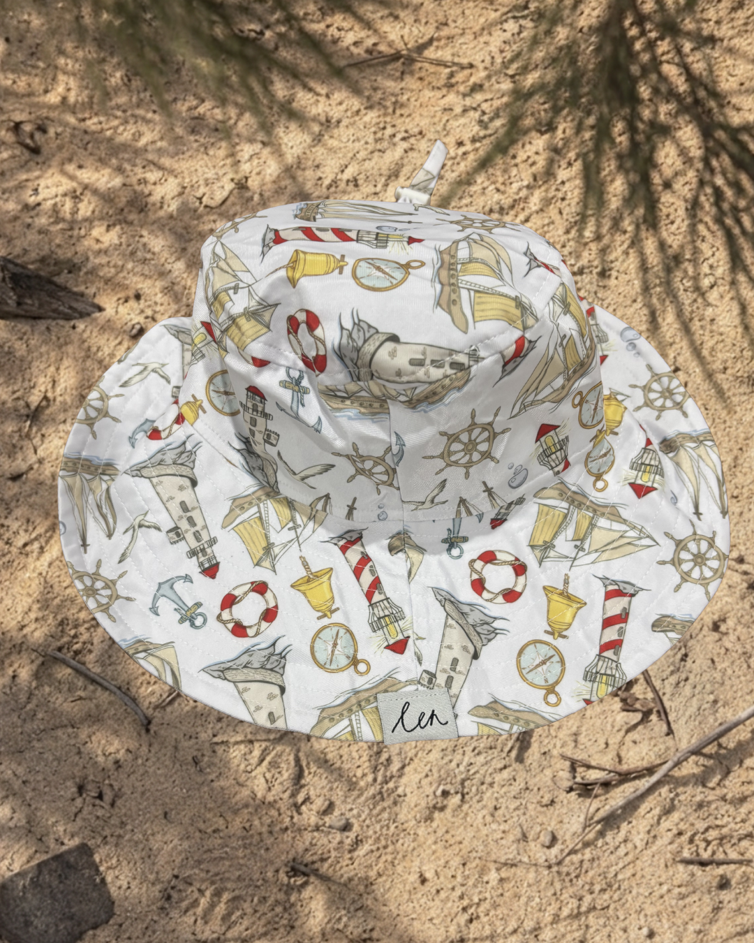 Bucket hat with nautical pattern on a sandy background
