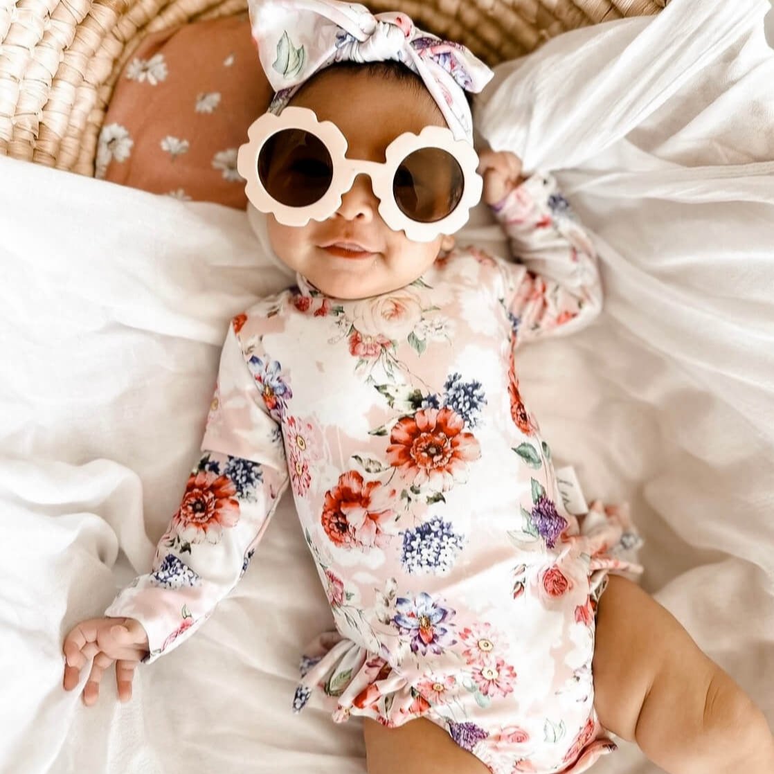Cute newborn baby wearing a long sleeve nappy change swimsuit with snaps for easy access for nappy changes and dressing.