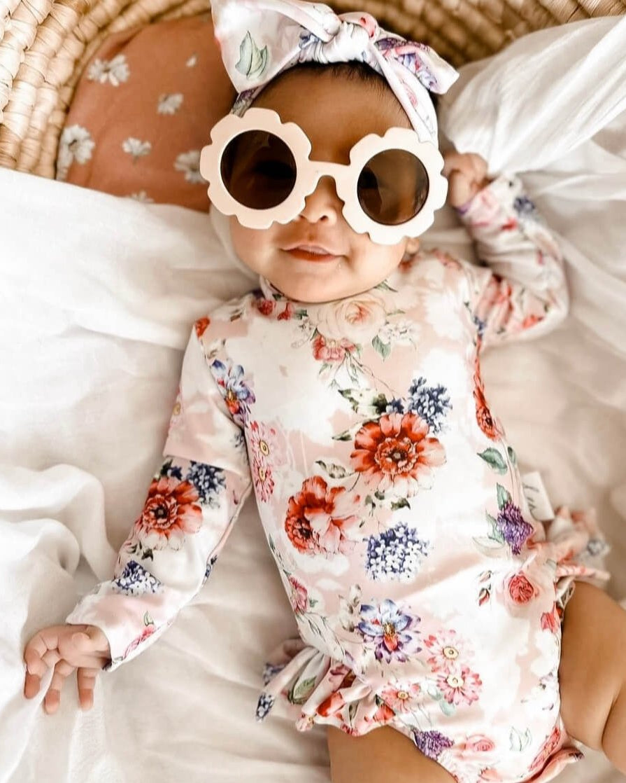 Cute newborn baby wearing a long sleeve nappy change swimsuit with snaps for easy access for nappy changes and dressing.