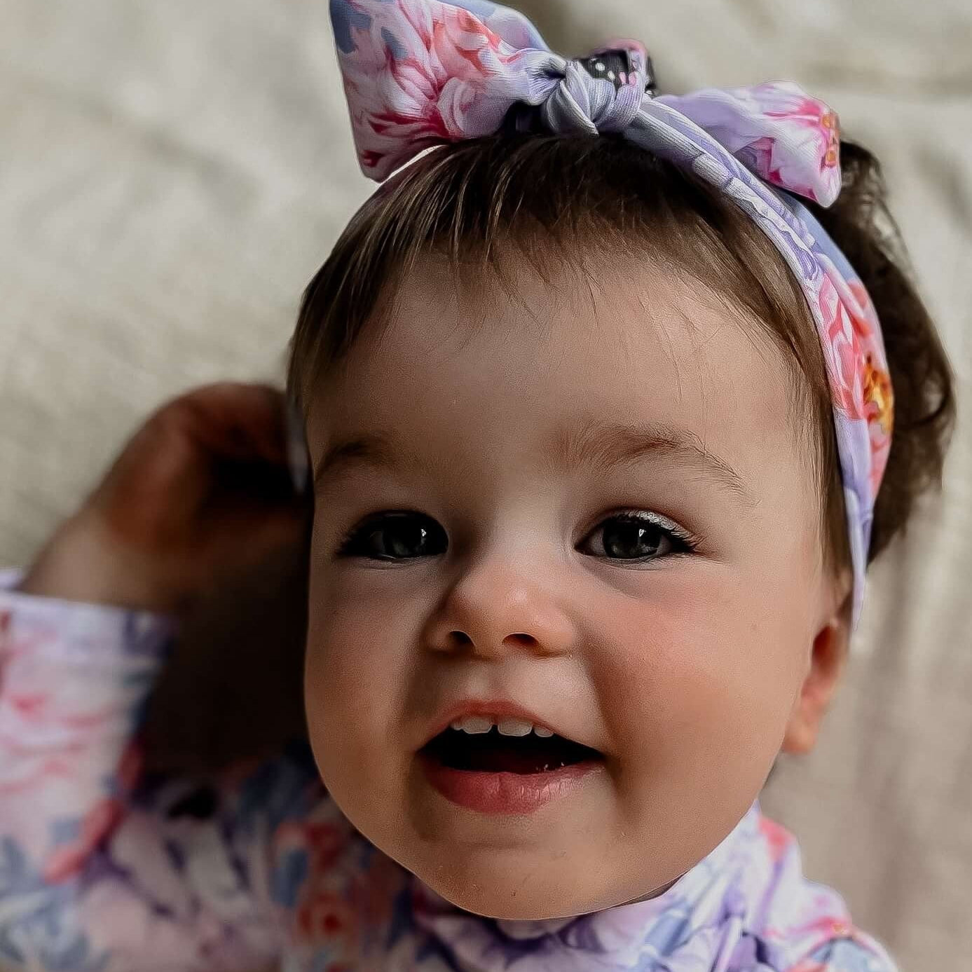 baby girl wearing a matching swimsuit with nappy change snaps and a matching headband that can be woen in the water