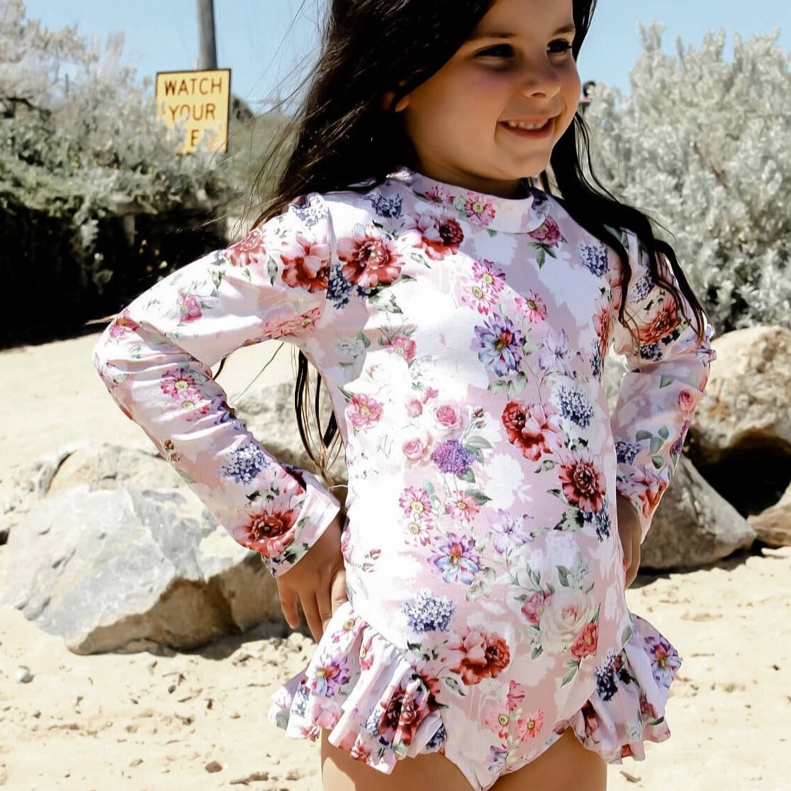 Girl wearing long sleeve floral pink snap change swimsuit