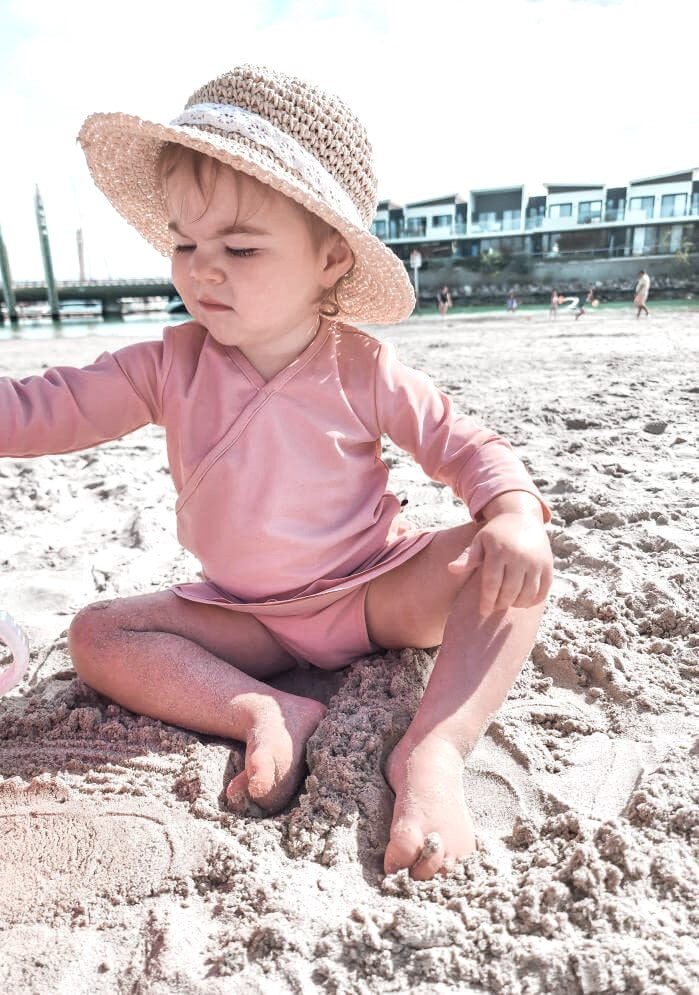 toddler girl playing at the beach in a premium ballet styles two piece swim set