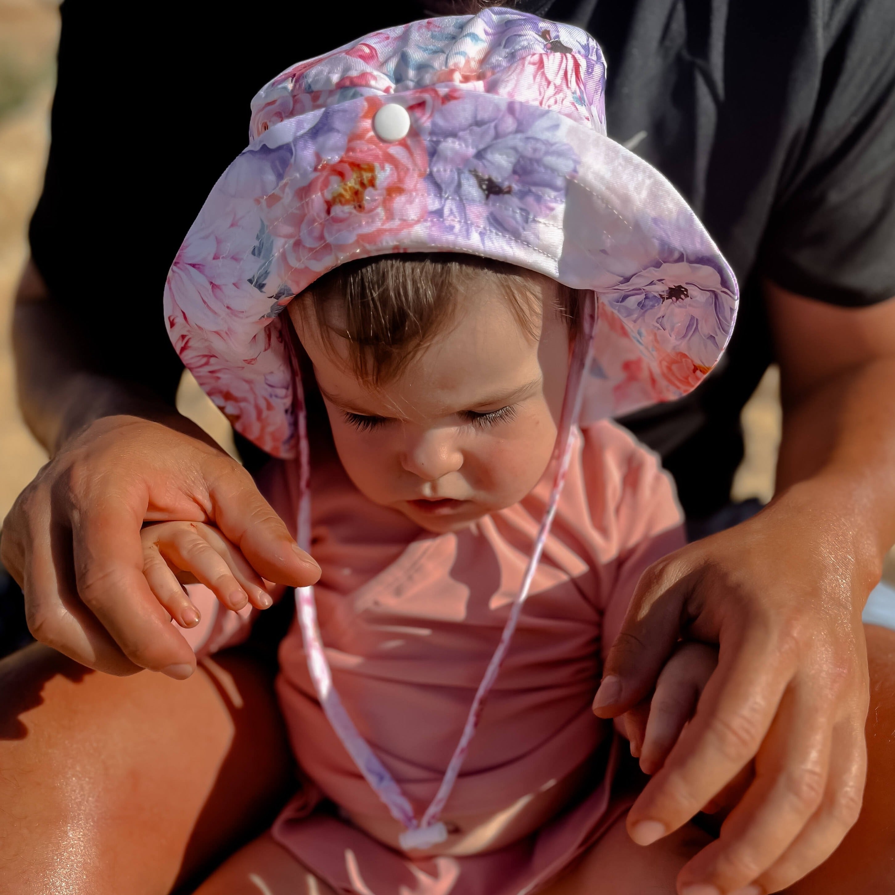 Baby girl wearing a pink rash vest set and swim hat