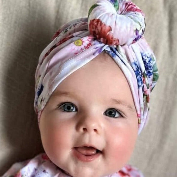 Baby wearing a matching swim turban and swimsuit long sleeve sun safe