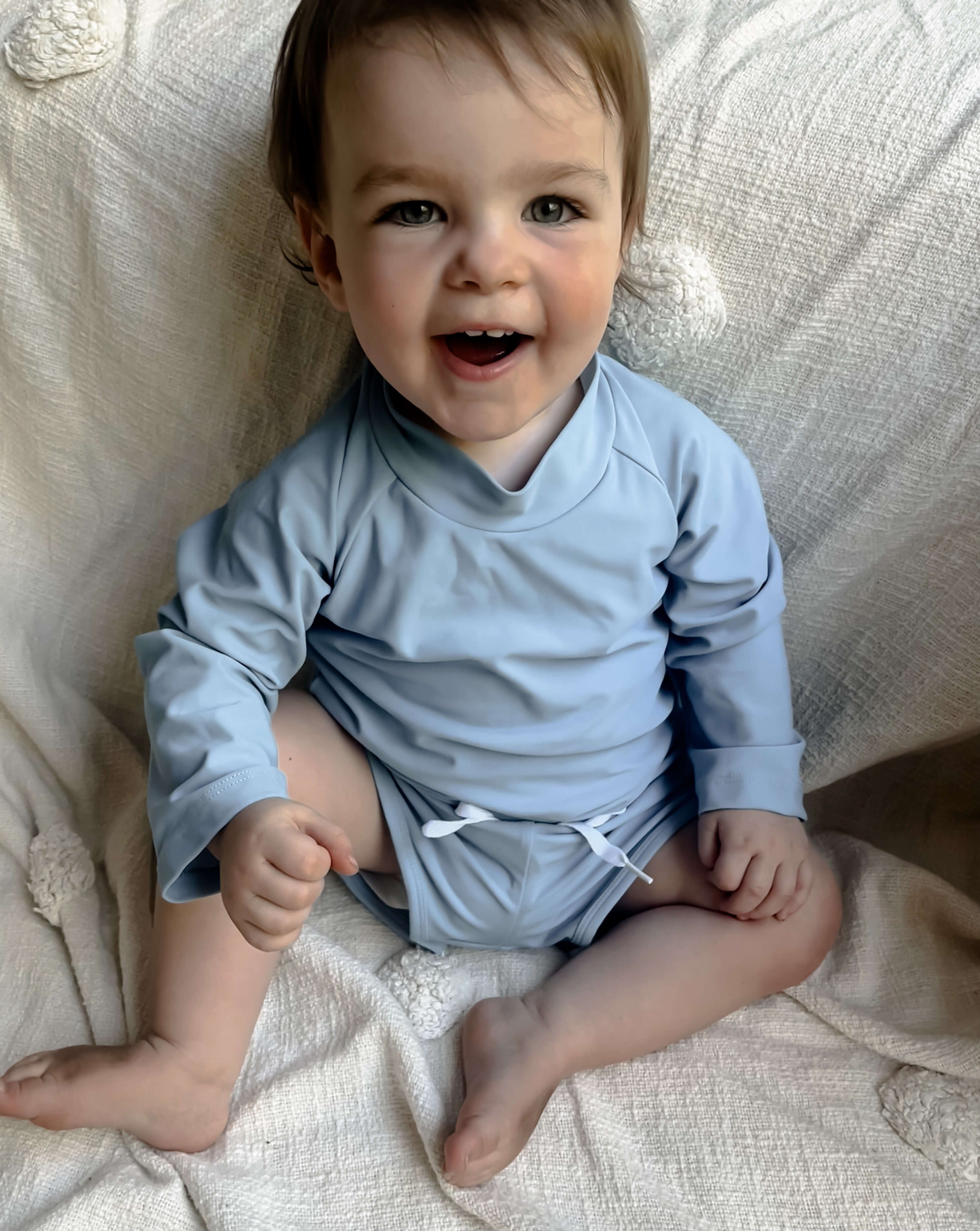 toddler baby wearing a premium blue rash swim set in a size 1
