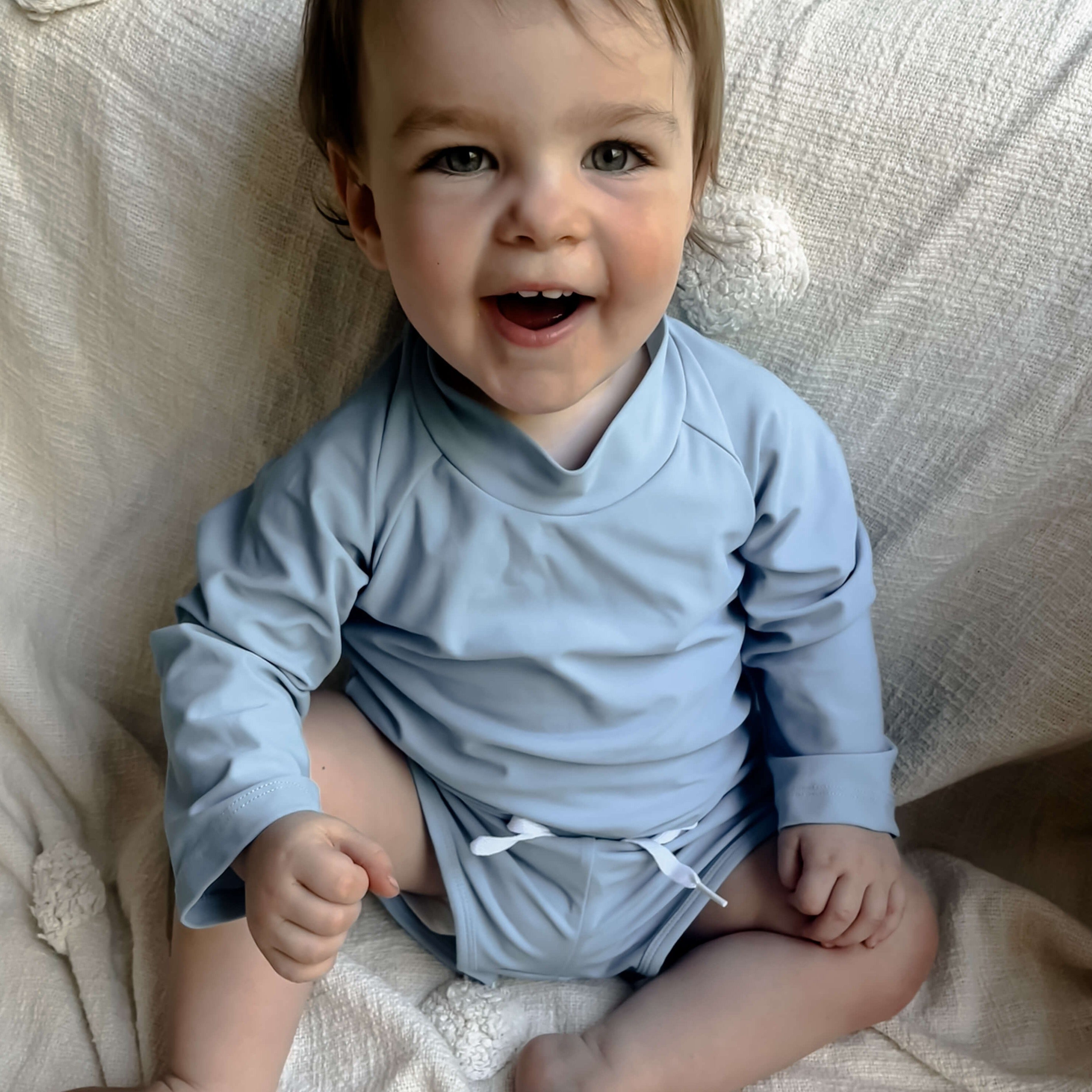 toddler baby wearing a premium blue rash swim set in a size 1