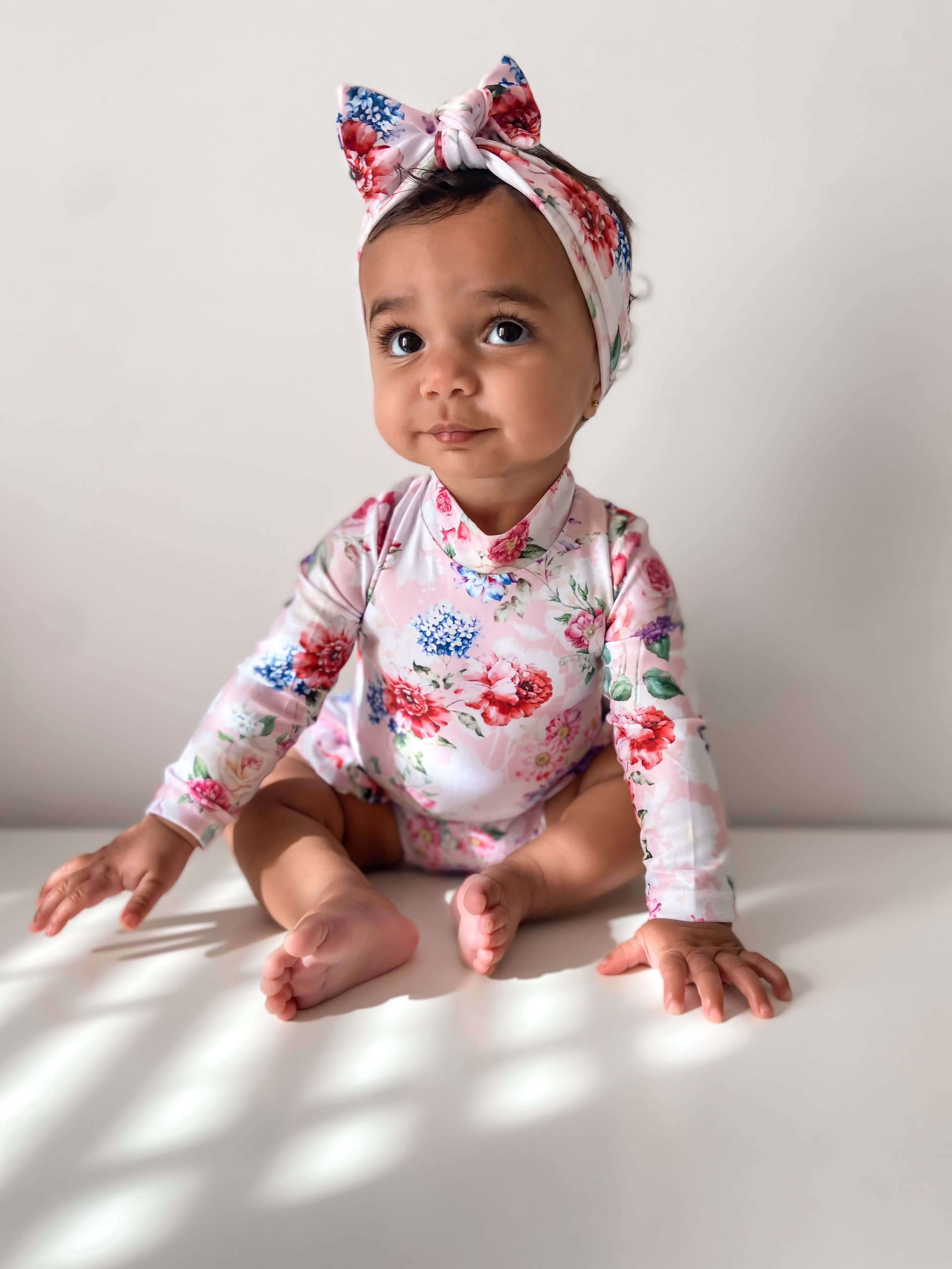 Baby girl with water safe headband and long sleeve floral nappy change swimsuit