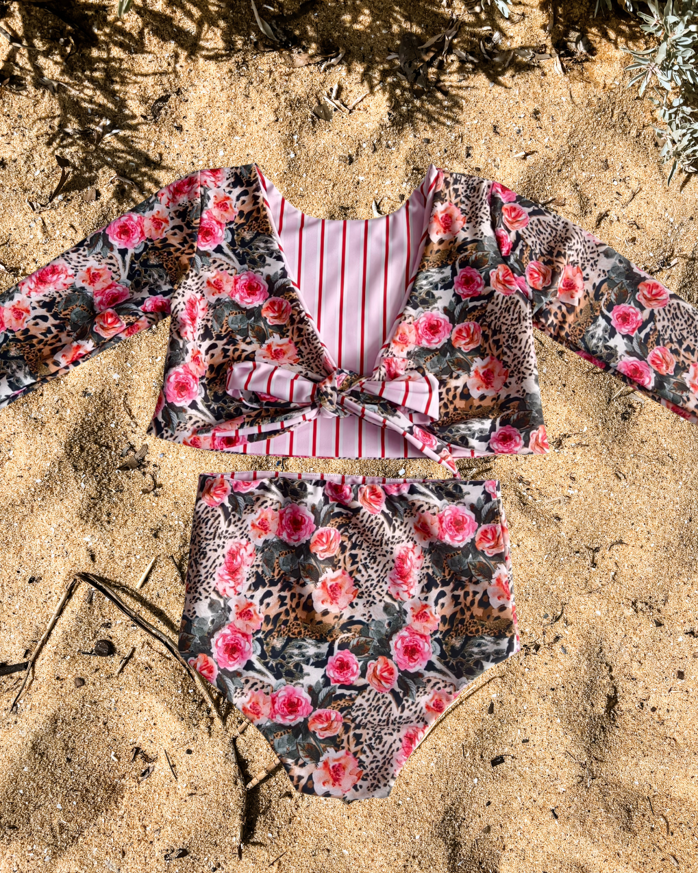 Floral and striped swimsuit on sandy ground