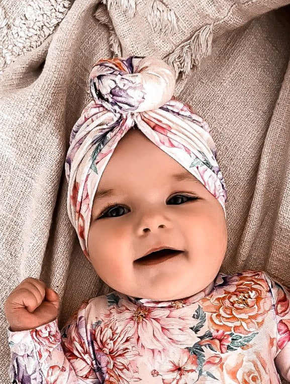 Baby wearing a swimsuit with matching head swim turban