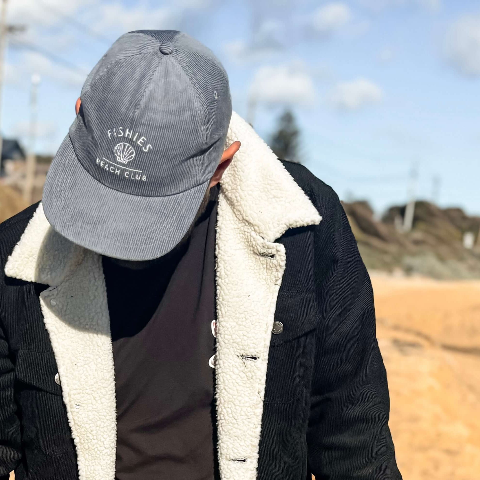 Two people walking on a sandy path with a clear sky. mens matching kids hat