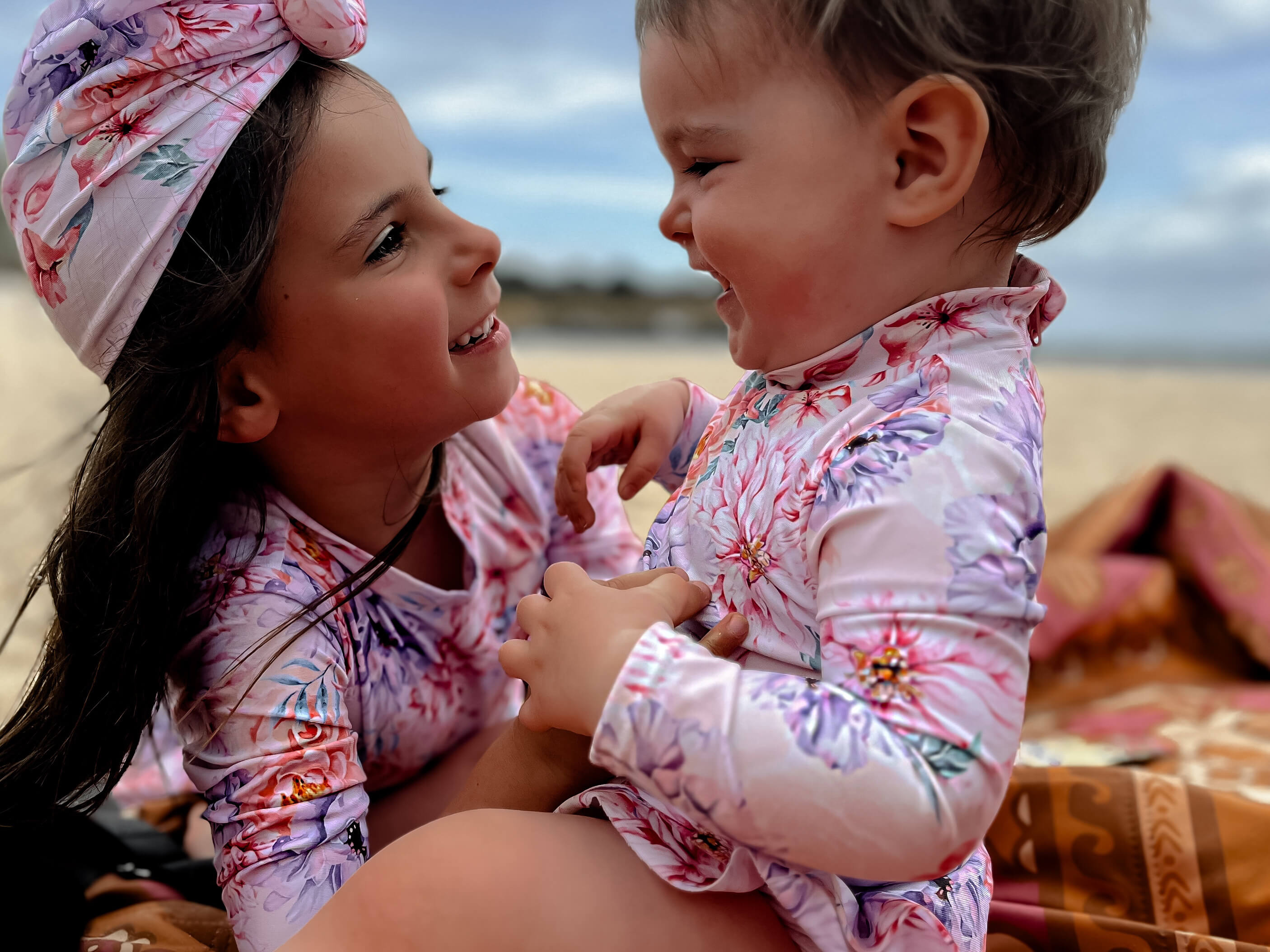 toddler and baby girl in cute long sleeve swimsuits