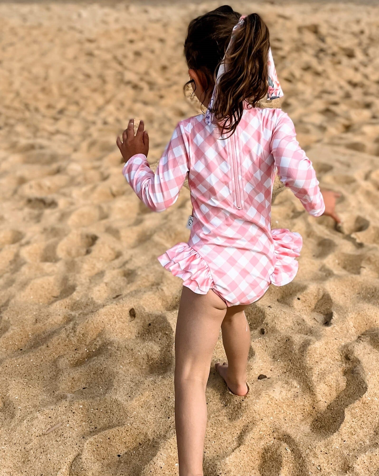 Young girl wearing a long sleeve swimsuit with change snaps