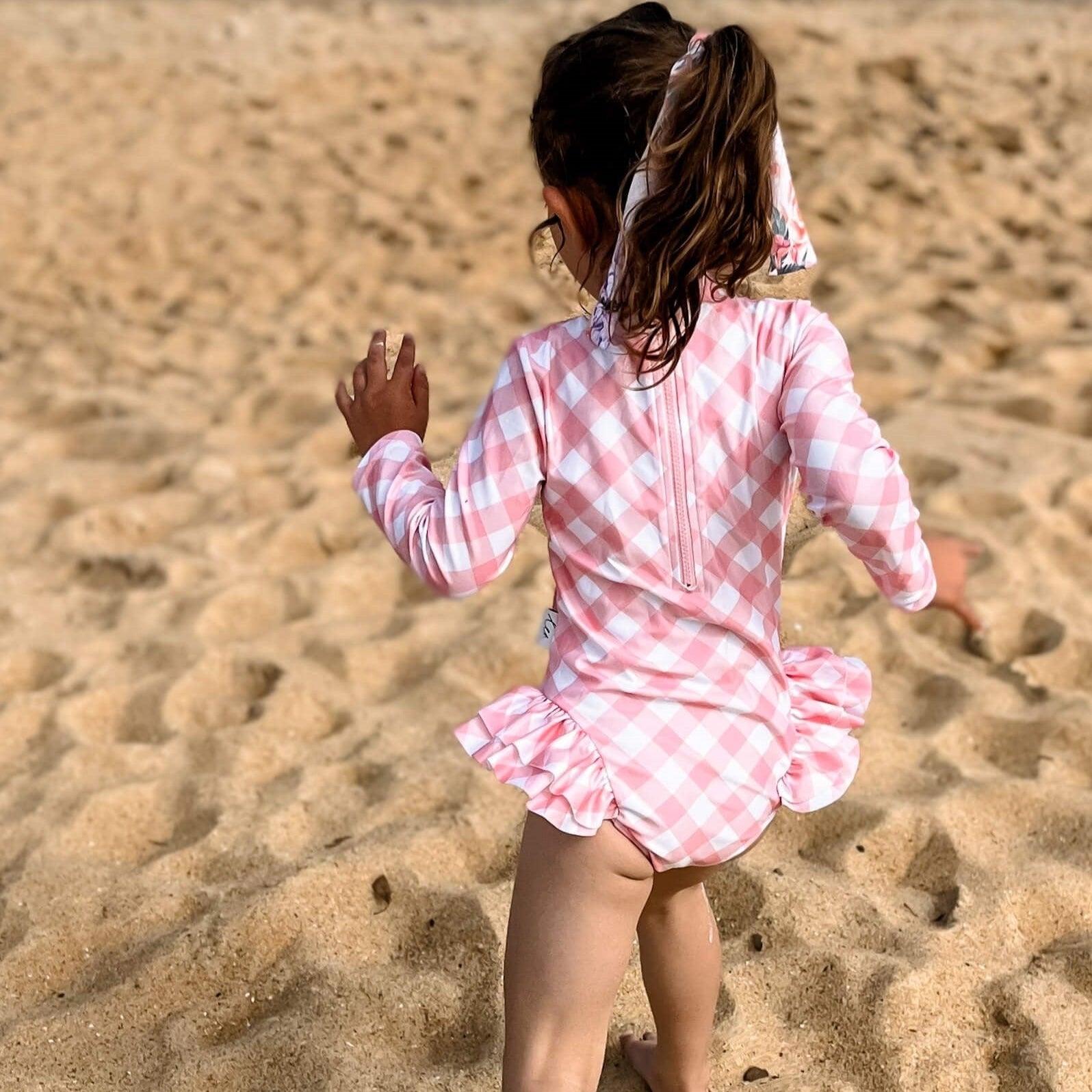 Young girl wearing a long sleeve swimsuit with change snaps