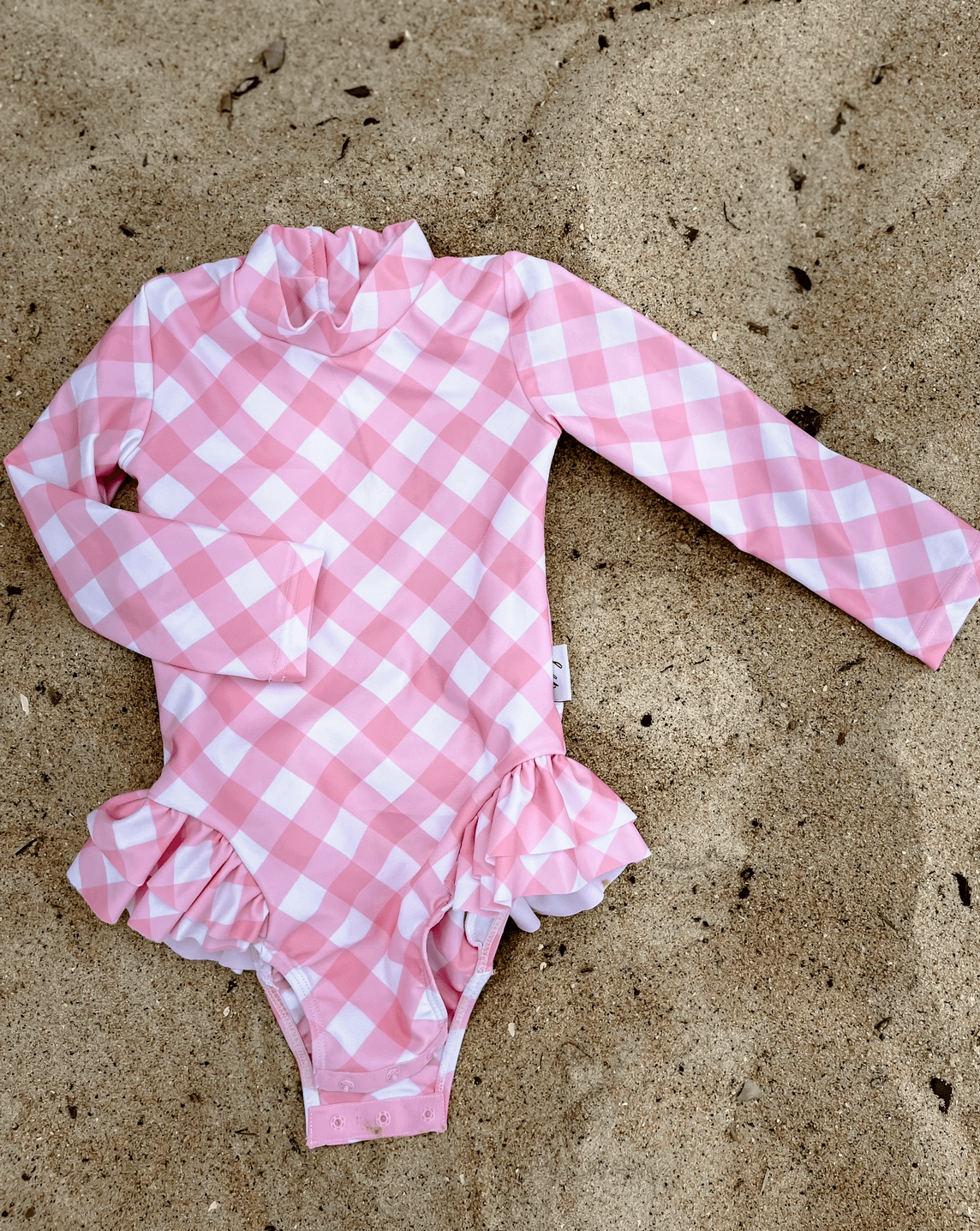 A pink gingham swimsuit with change snaps in sizes from newborn, toddler and school age