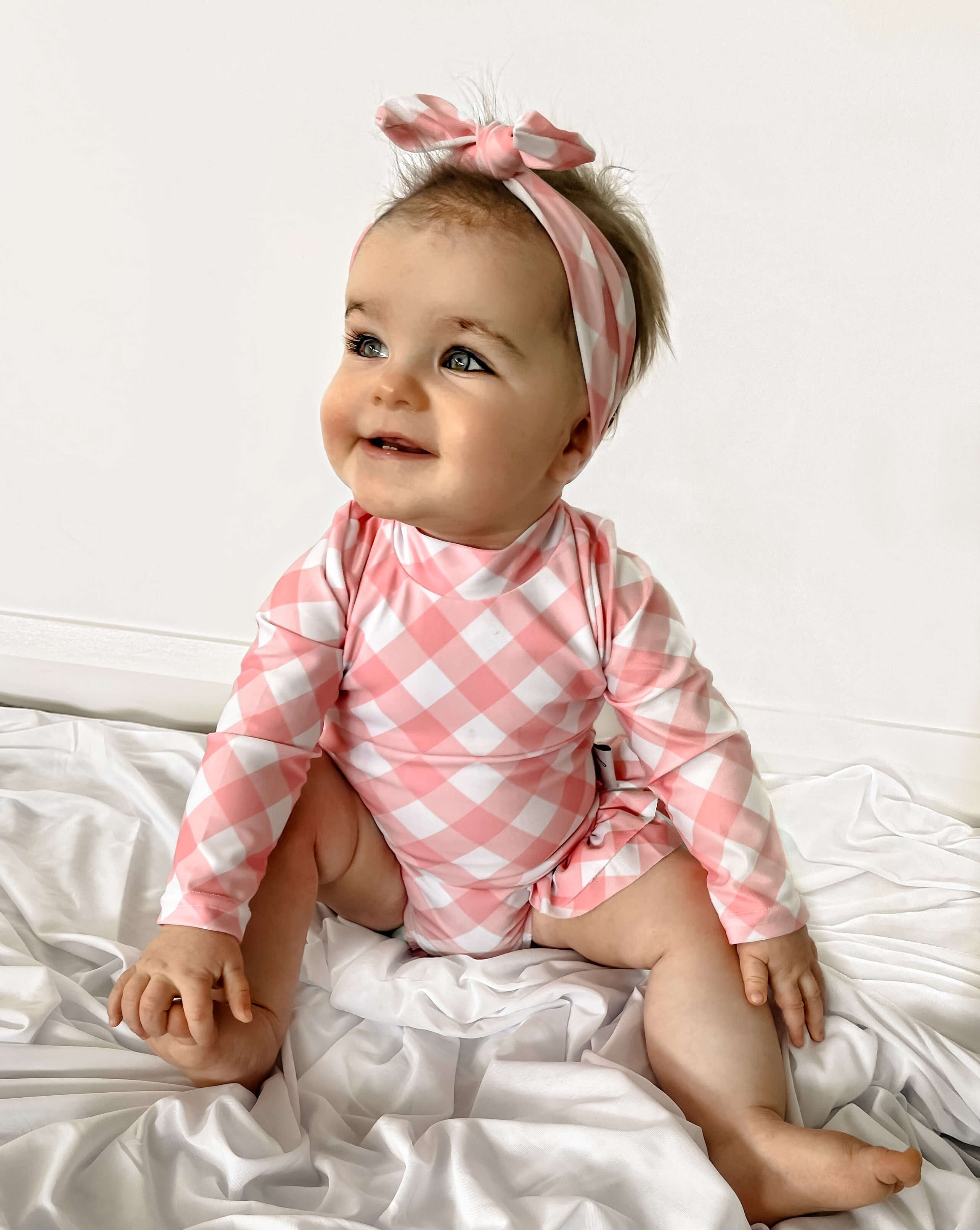 Baby girl in pink gingham print swimsuit with nappy change snap swimwear 