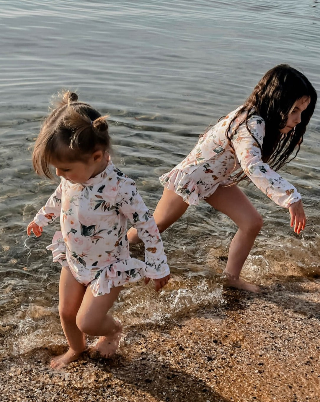 little girls playing in the water wearing a nappy change swimsuit