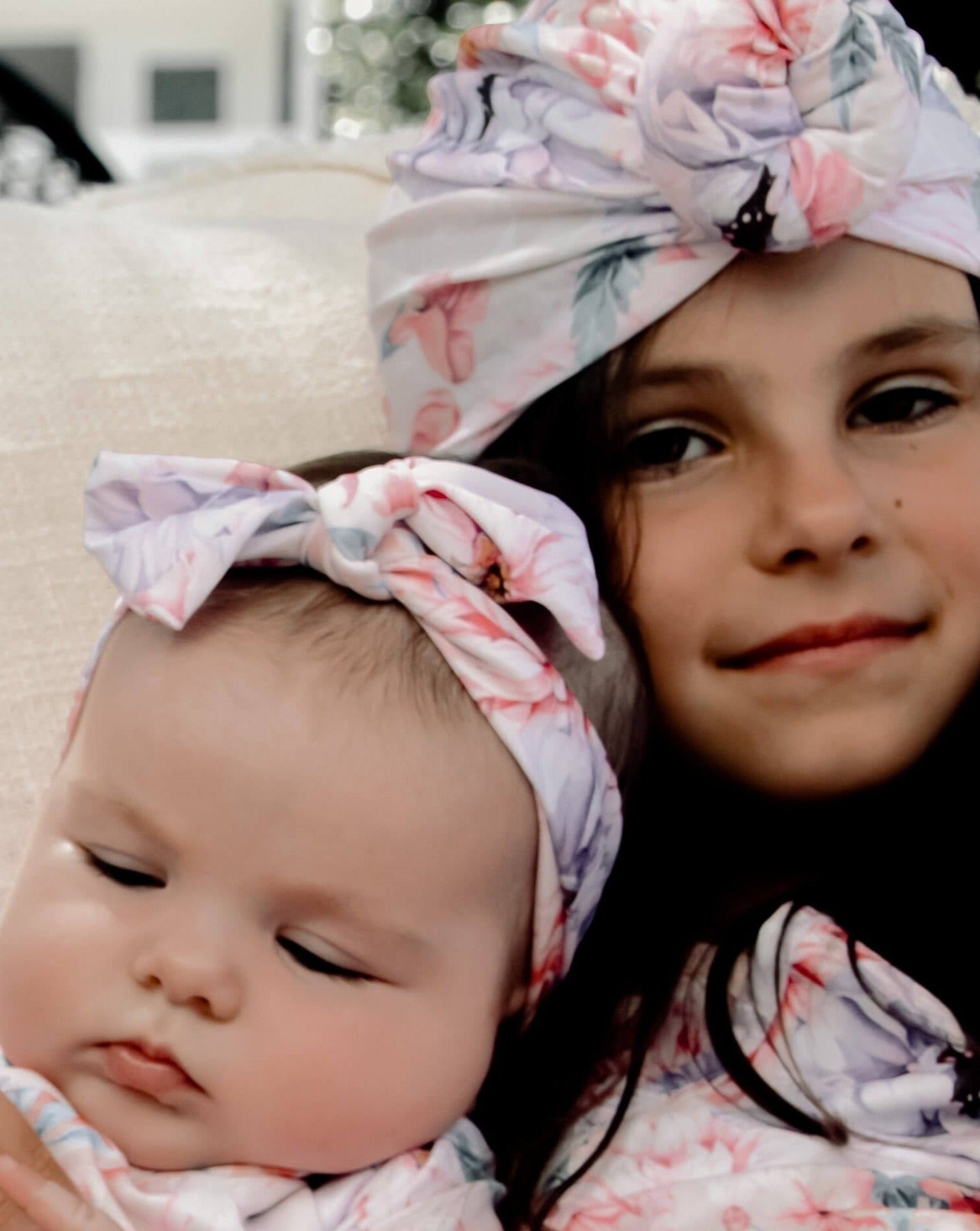 Baby and younf girl wearing matching swimsuits and a swim turban and headband in floral print