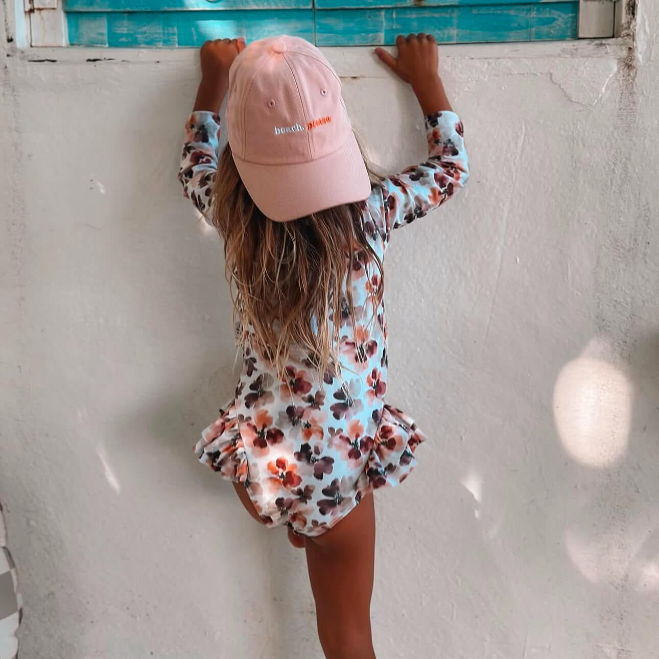 baby toddler and girls long sleeve UPF50 swimsuit with changing snaps and a pink girls baseball hat that says beach, please