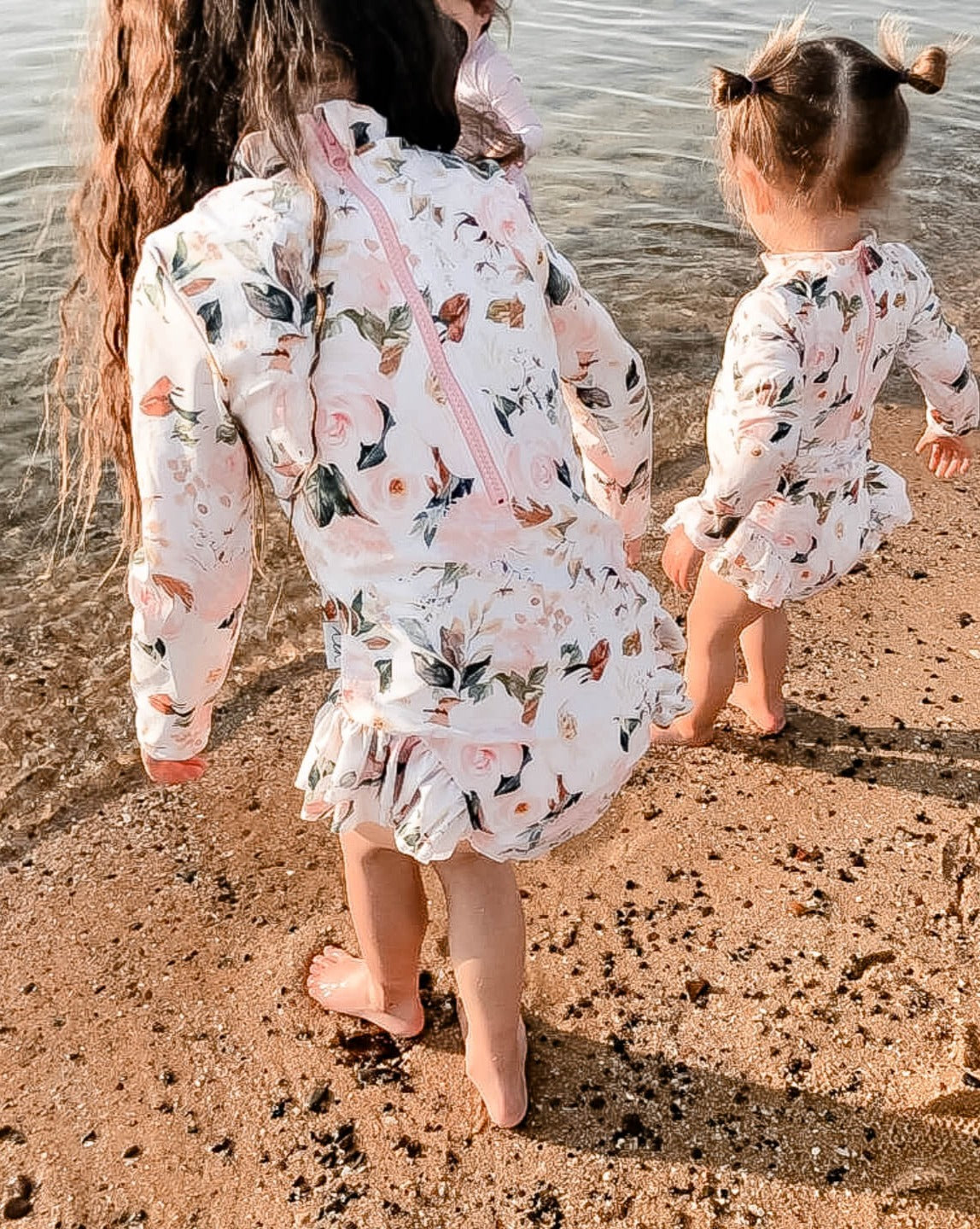 toddler and girl in a long sleeve floral premium nappy change swimsuit