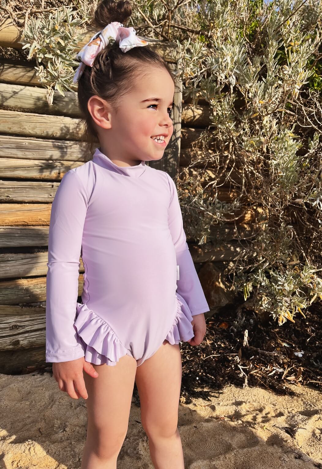 toddler girl at beach at sunset playing in a nappy change long sleeve premium swimsuit