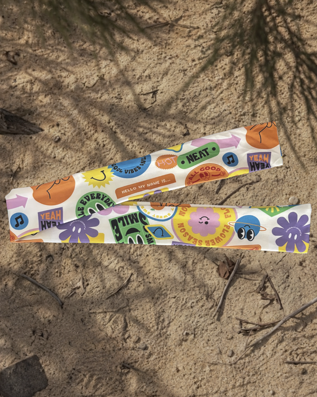 Colorful water headband with various designs on a sandy surface