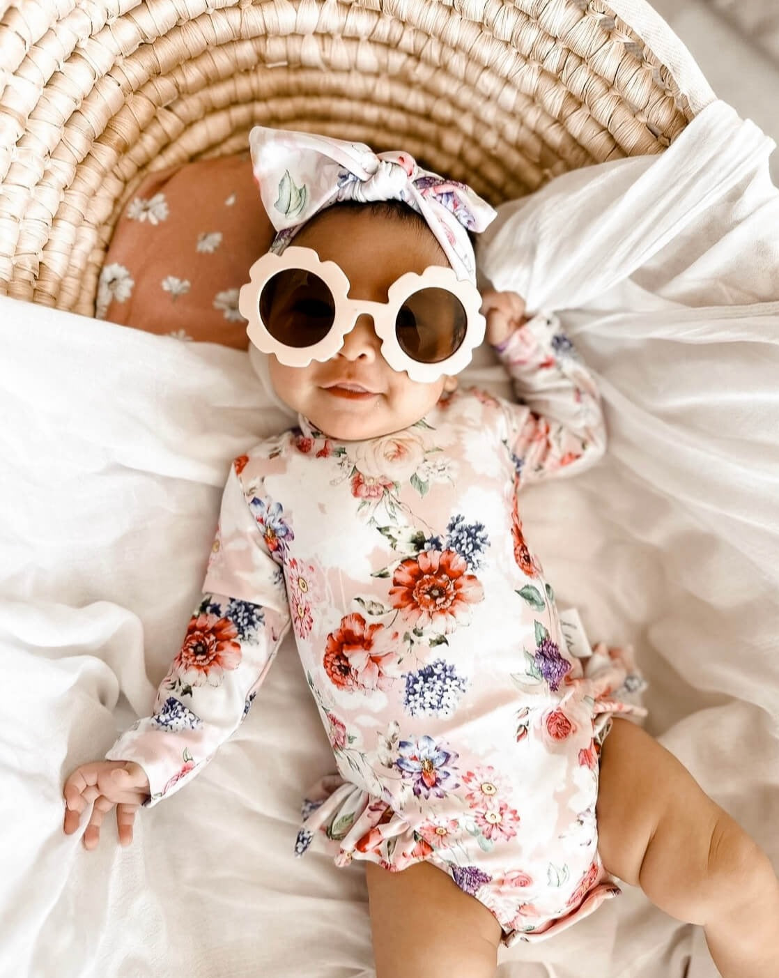 Cute newborn baby wearing a long sleeve nappy change swimsuit with snaps for easy access for nappy changes and dressing. 