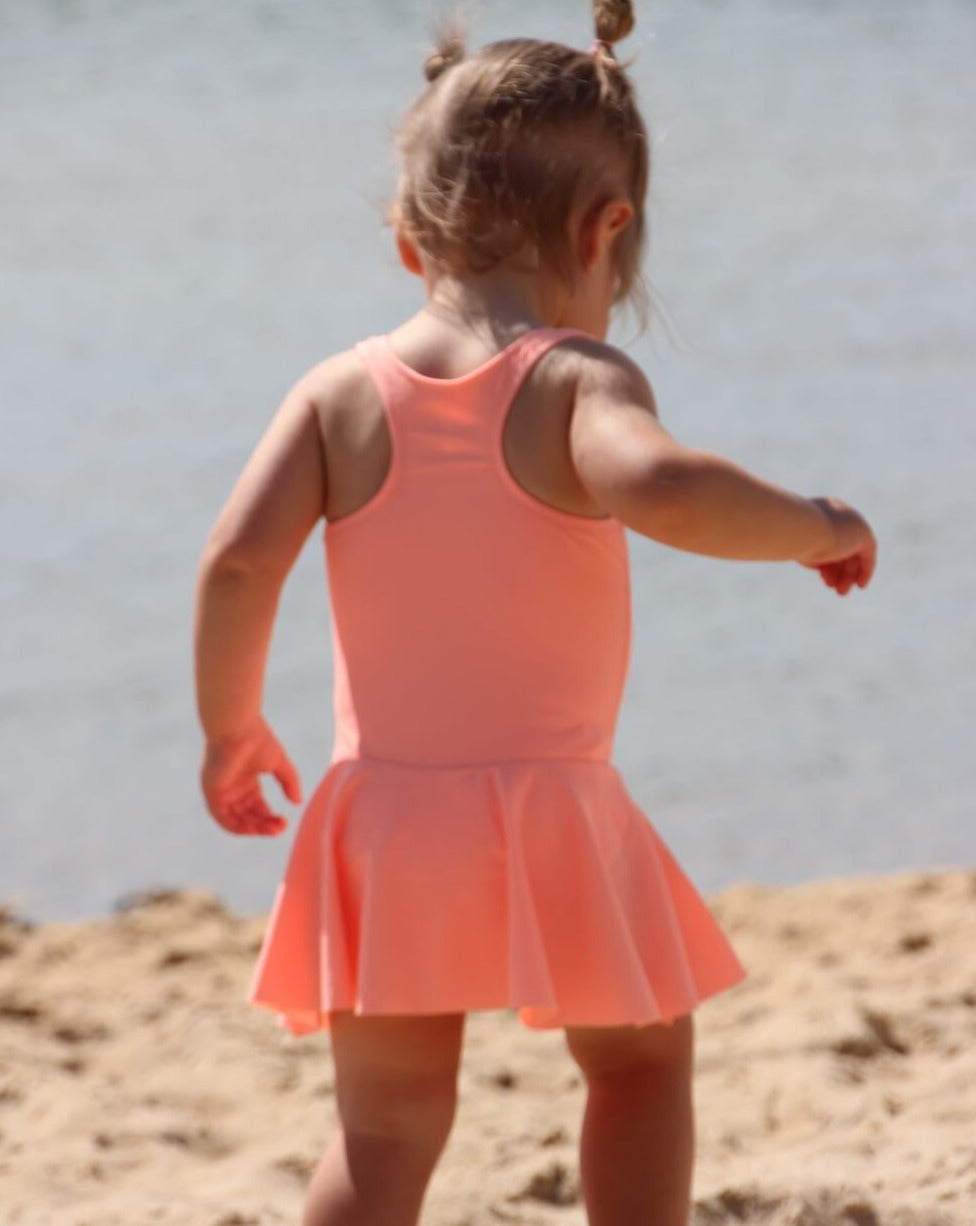 toddler in a bright orange swim dress with nappy change snaps