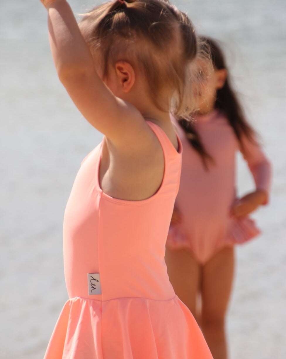 toddler in a bright orange swim dress with nappy change snaps