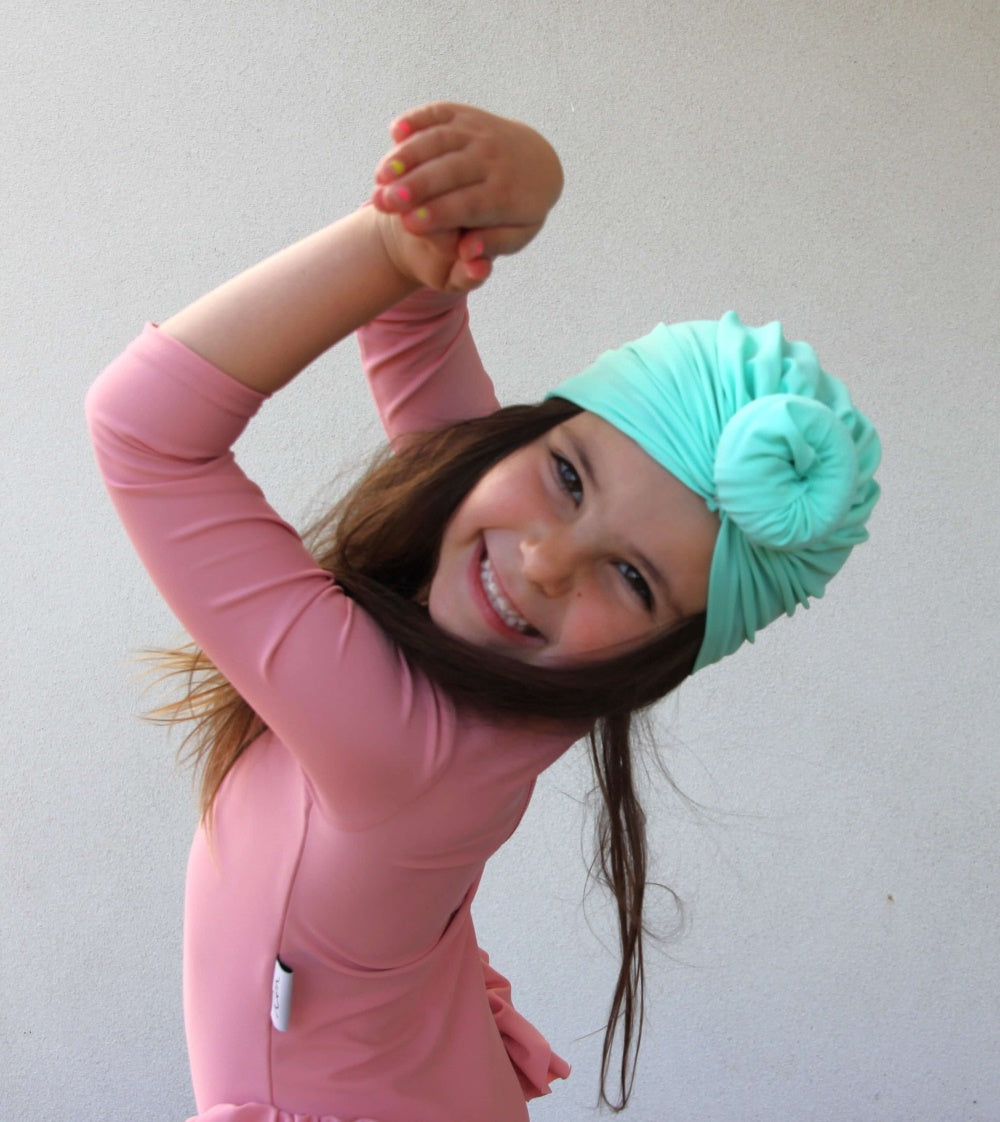 girl wearing green sun safe swim turban