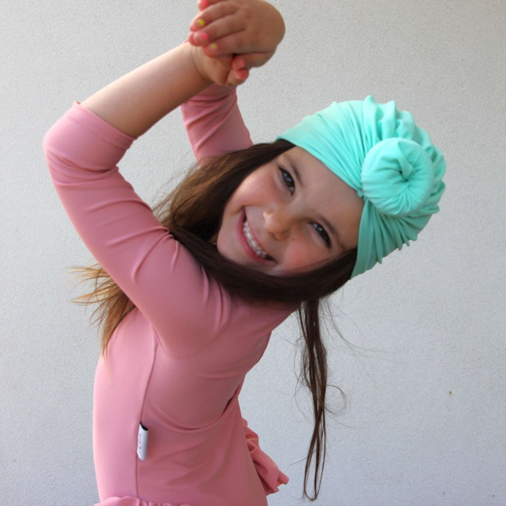 girl wearing green sun safe swim turban